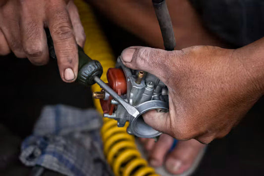 Wide horizontal landscape shot of a technician using a feeler gauge to measure spark plug electrode gap